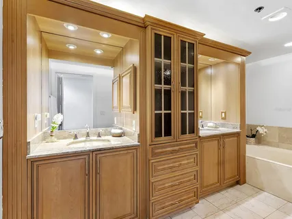 a bathroom with a tub a sink and mirror