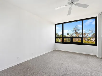 a bedroom with a large bed couch and a large window
