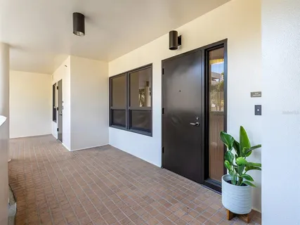 a view of a hallway with wooden floor and a potted plant