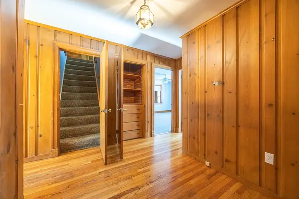 a view of a hallway with wooden floor and staircase