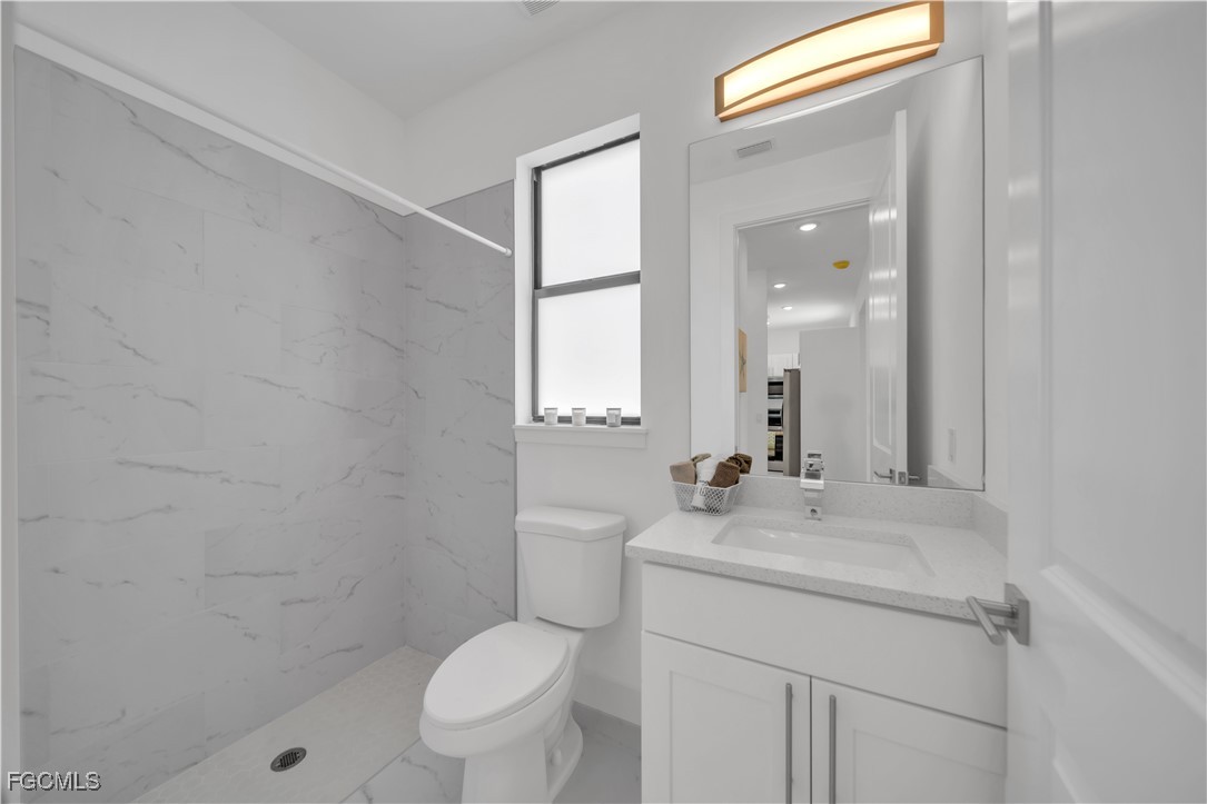 936-938 Homestead Road South Lehigh Acres, FL 33974 - Photo 9 of 9 a bathroom with a sink toilet vanity and a mirror