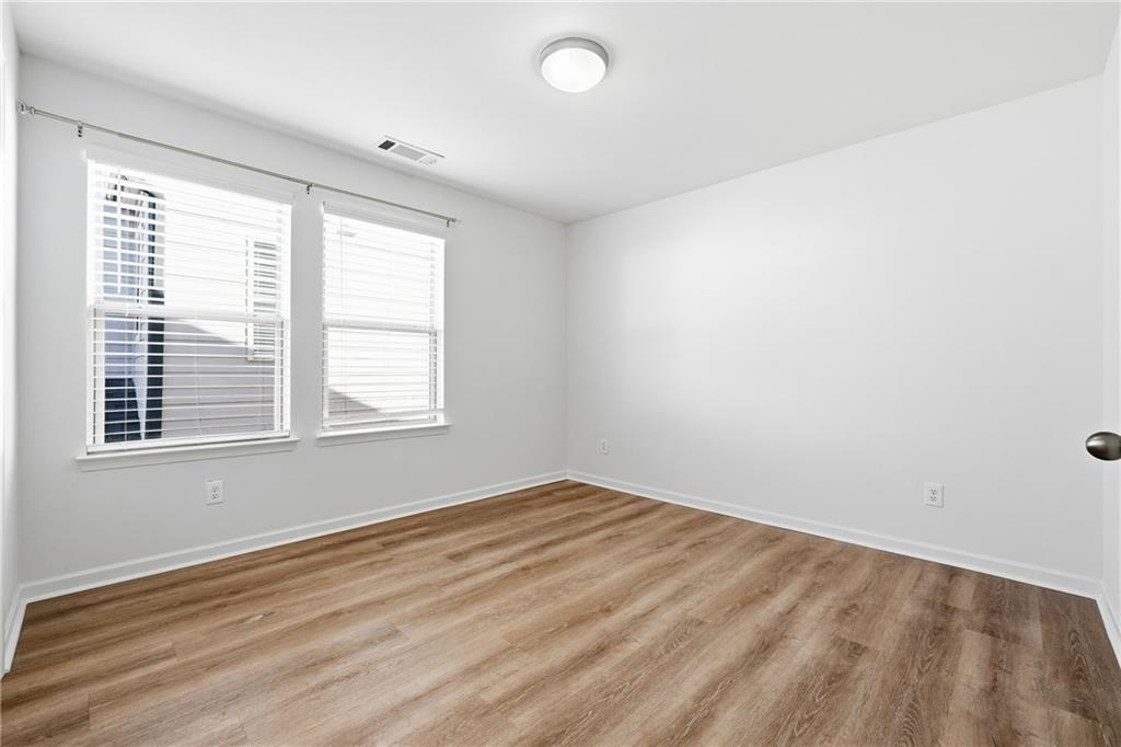 2719 Morgan Spring Trail Buford, GA 30519 - Photo 14 of 46 an empty room with wooden floor and windows