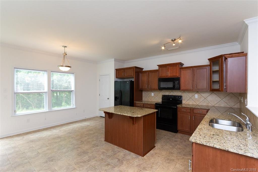9609 Fernspray Road Charlotte, NC 28213 - Photo 12 of 30 a kitchen with granite countertop kitchen island stainless steel appliances a sink stove and refrigerator