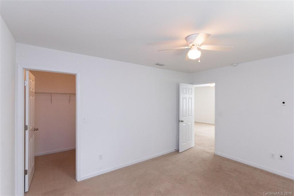 9609 Fernspray Road Charlotte, NC 28213 - Photo 17 of 30 an empty room with a chandelier fan and a bathroom