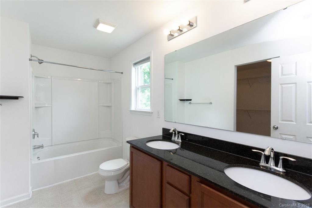9609 Fernspray Road Charlotte, NC 28213 - Photo 25 of 30 a bathroom with a granite countertop sink toilet a mirror and shower