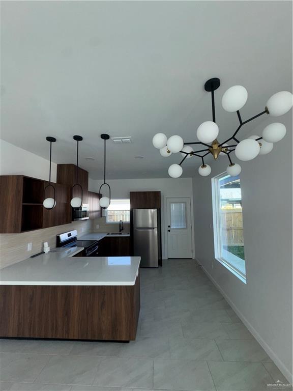 104 Sunflower Street, Unit 1 Mission, TX 78572 - Photo 6 of 21 a living room with furniture a chandelier and a flat screen tv
