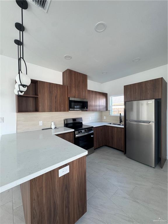 104 Sunflower Street, Unit 1 Mission, TX 78572 - Photo 9 of 21 a kitchen with stainless steel appliances a refrigerator sink and stove