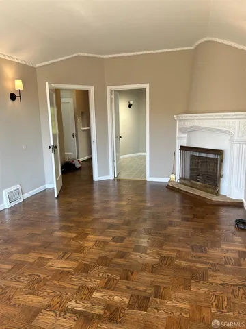 a view of empty room with wooden floor and fireplace