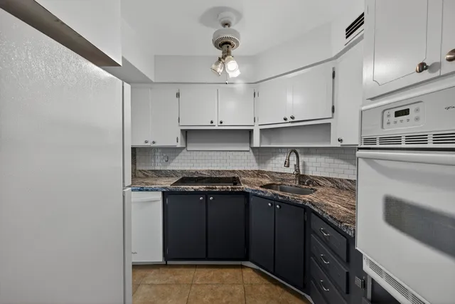 a kitchen with stainless steel appliances granite countertop a sink stove cabinets and refrigerator