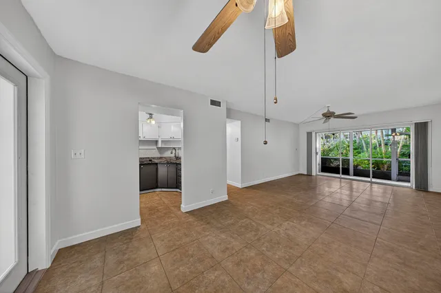 a view of empty room with wooden floor and windows