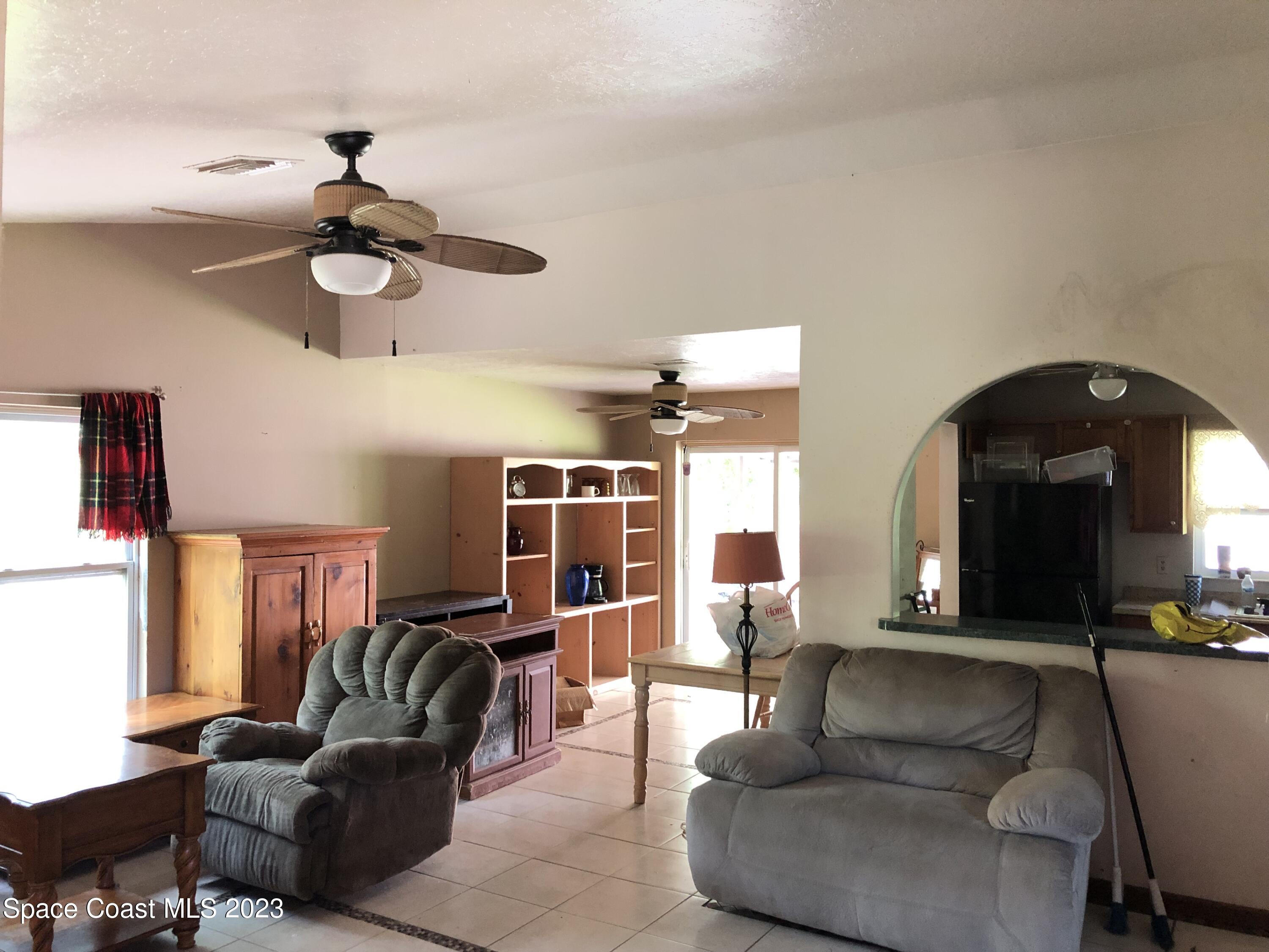 750 Fletcher Road Southeast Palm Bay, FL 32909 - Photo 2 of 12 a living room with furniture and a chandelier
