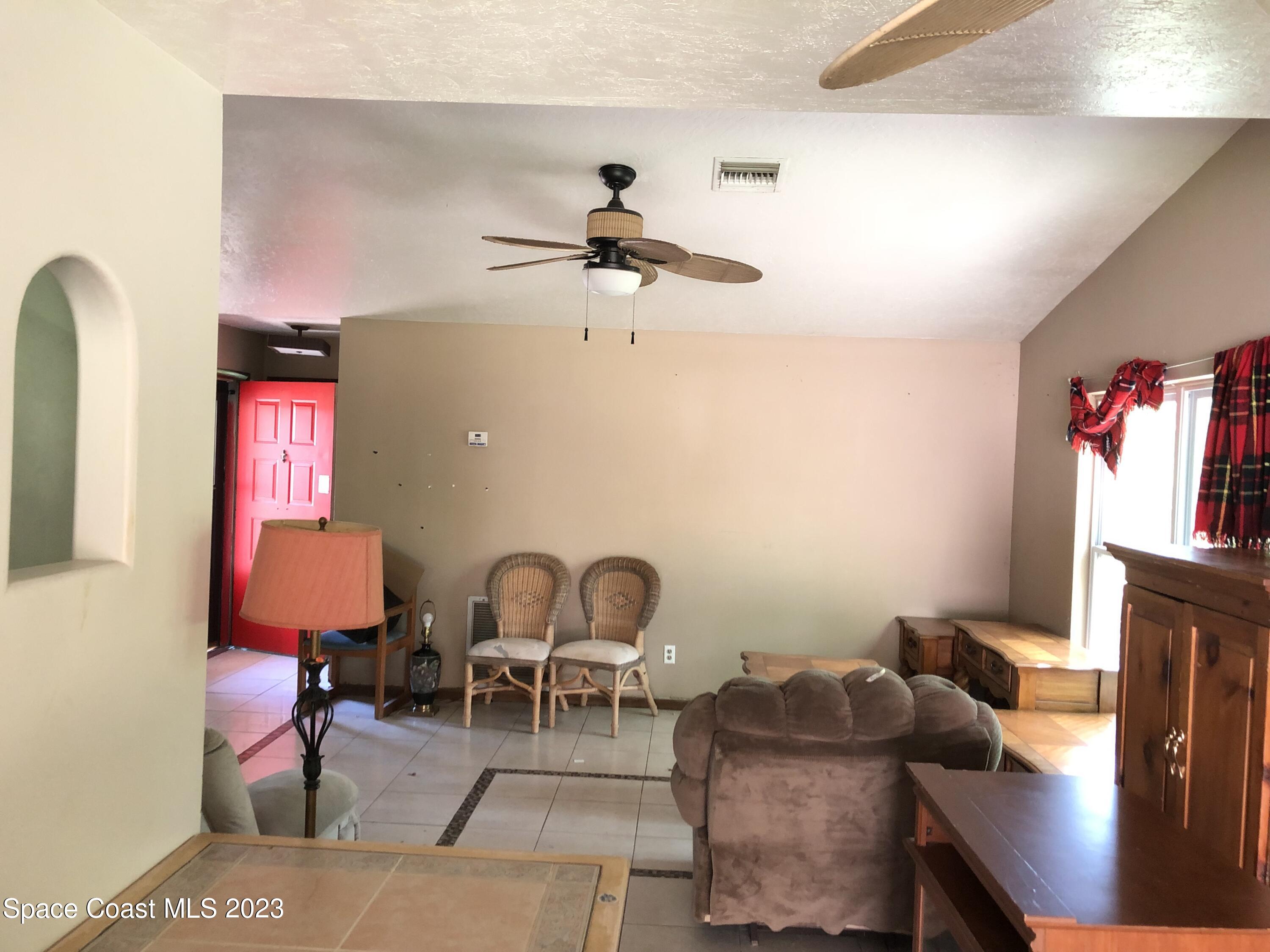 750 Fletcher Road Southeast Palm Bay, FL 32909 - Photo 3 of 12 a living room with furniture and a chandelier