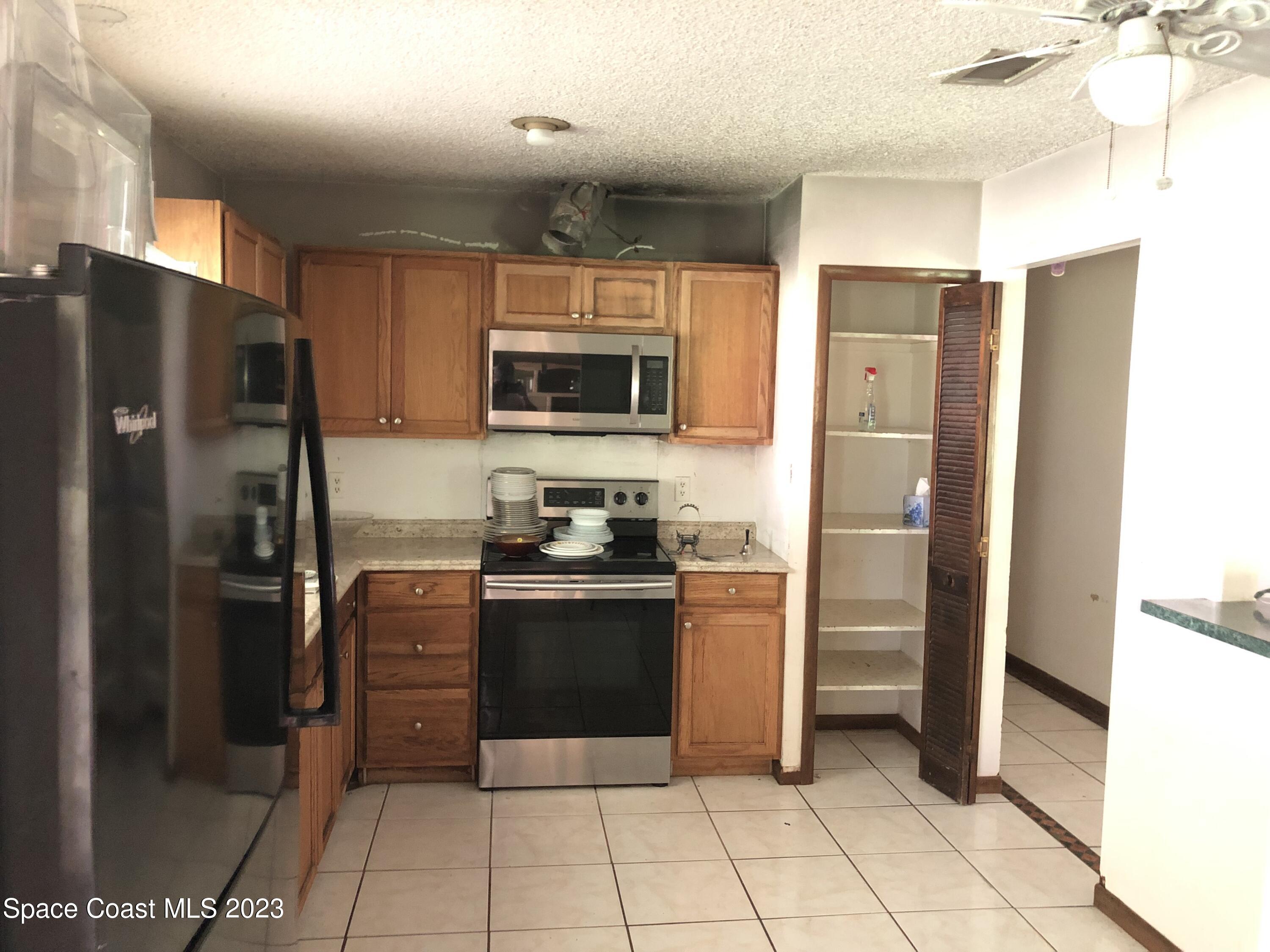 750 Fletcher Road Southeast Palm Bay, FL 32909 - Photo 5 of 12 a kitchen with stainless steel appliances granite countertop a refrigerator and a stove top oven