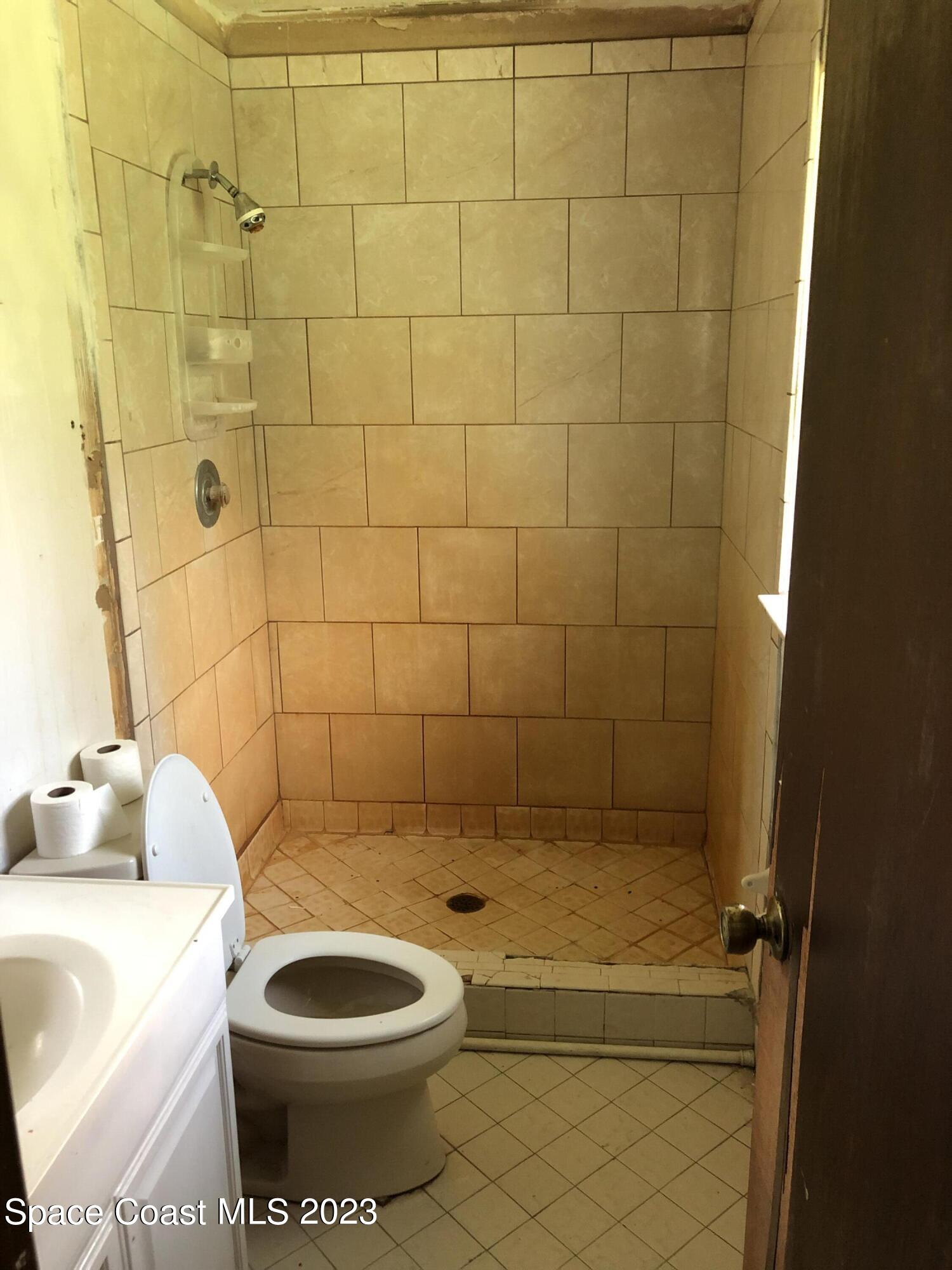 750 Fletcher Road Southeast Palm Bay, FL 32909 - Photo 7 of 12 a bathroom with a toilet and a shower