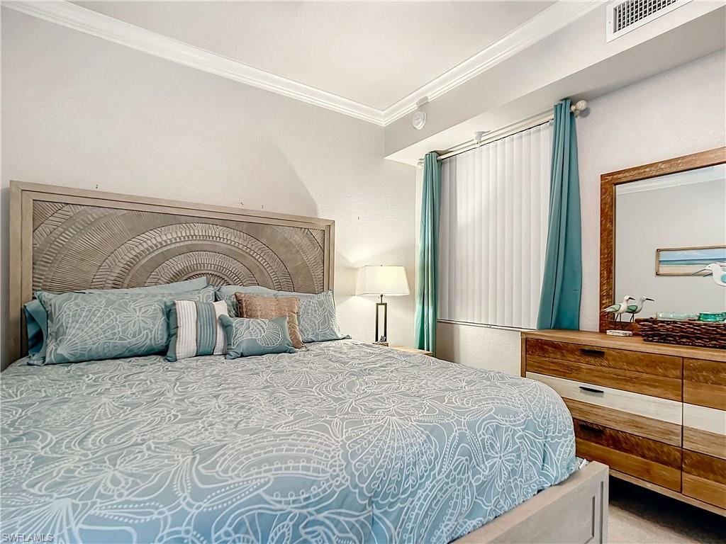 9715 Acqua Court, Unit 127 Naples, FL 34113 - Photo 29 of 50 a bedroom with a large bed and a dresser