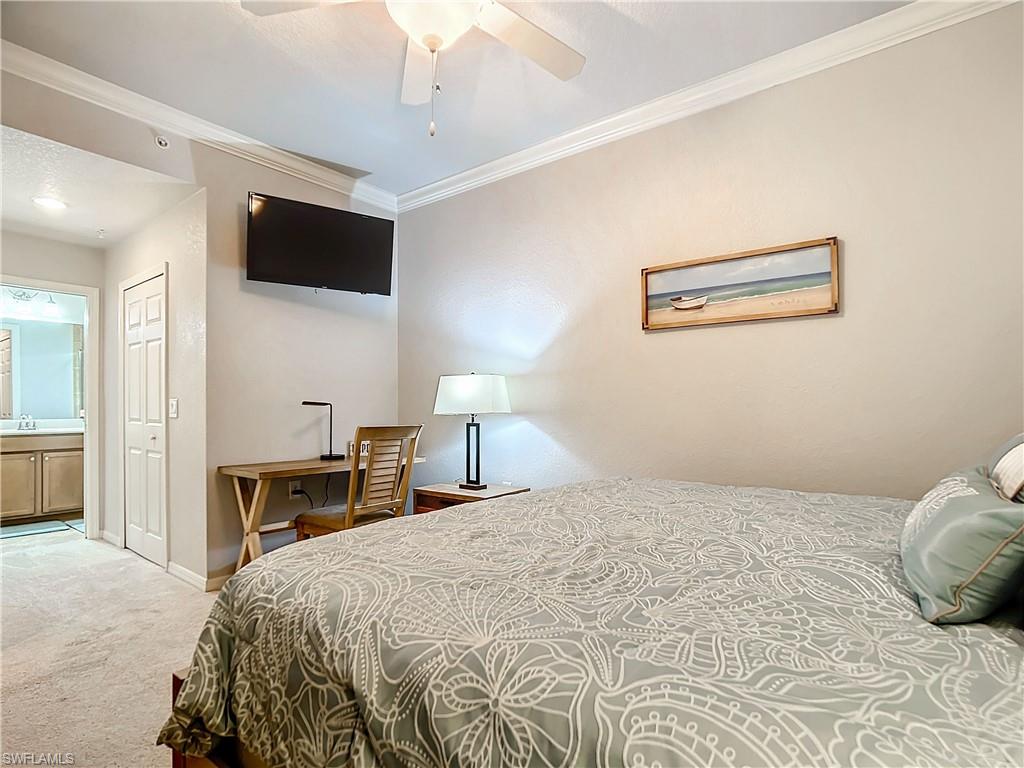 9715 Acqua Court, Unit 127 Naples, FL 34113 - Photo 32 of 50 a bedroom with a bed and a flat screen tv