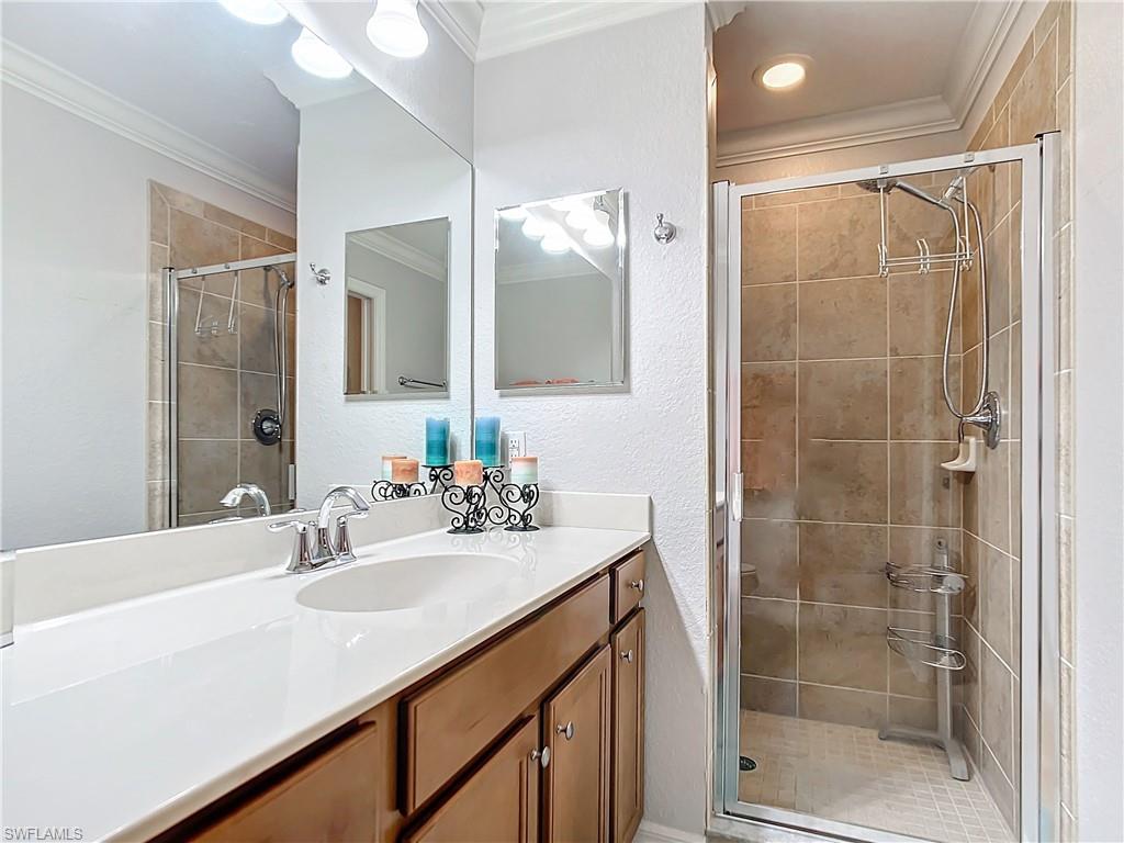 9715 Acqua Court, Unit 127 Naples, FL 34113 - Photo 34 of 50 a bathroom with a sink shower and a mirror