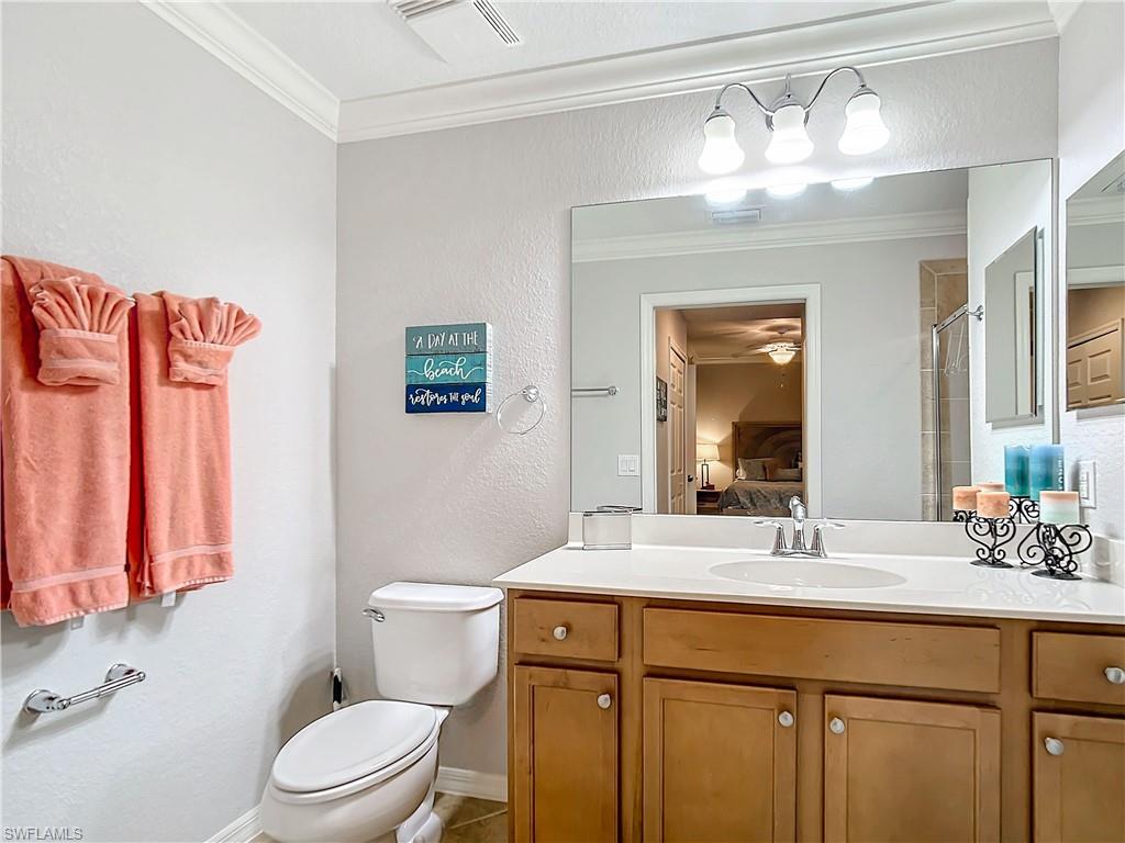 9715 Acqua Court, Unit 127 Naples, FL 34113 - Photo 35 of 50 a bathroom with a sink a toilet and a mirror