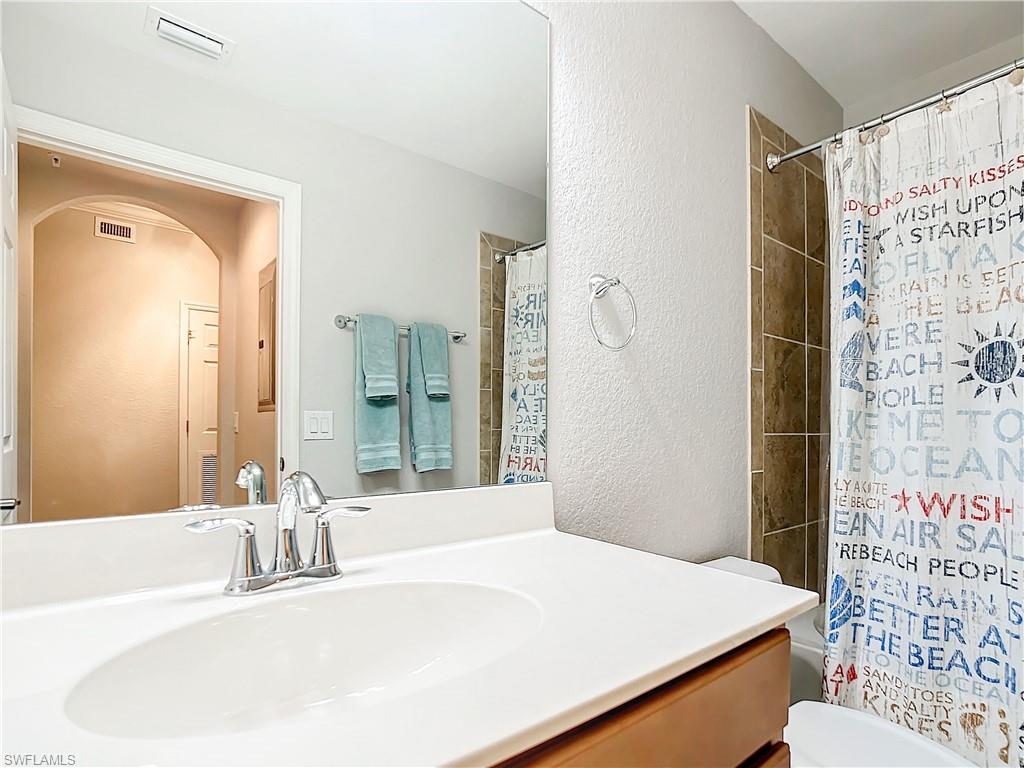 9715 Acqua Court, Unit 127 Naples, FL 34113 - Photo 39 of 50 a bathroom with a sink and a mirror