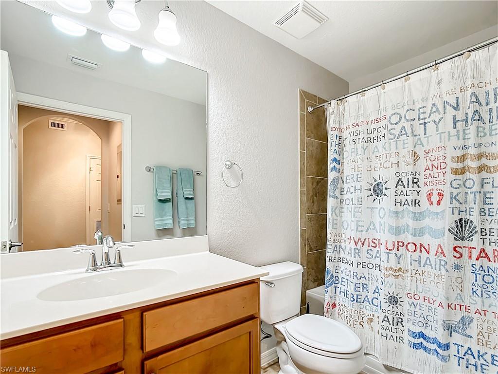 9715 Acqua Court, Unit 127 Naples, FL 34113 - Photo 40 of 50 a bathroom with a sink a toilet and shower curtain