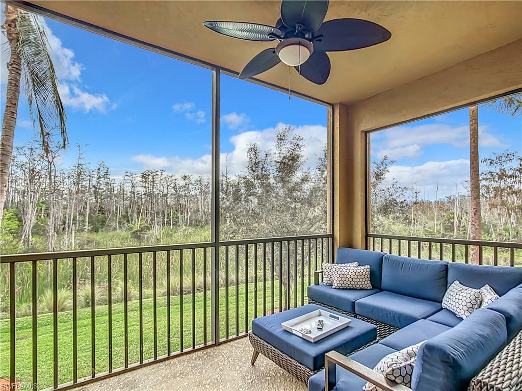 9715 Acqua Court, Unit 127 Naples, FL 34113 - Photo 44 of 50 a living room with furniture and a floor to ceiling window