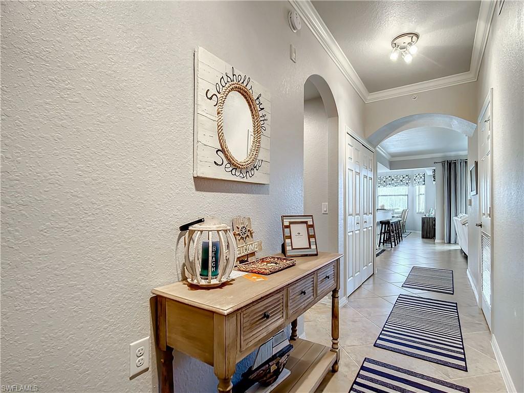 9715 Acqua Court, Unit 127 Naples, FL 34113 - Photo 7 of 50 a hallway with a table and couch