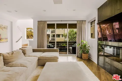 a living room with furniture and flower plants