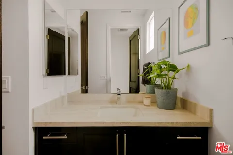 a bathroom with a granite countertop sink a mirror and vanity