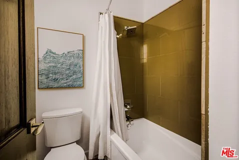 a bathroom with a toilet and a shower curtain