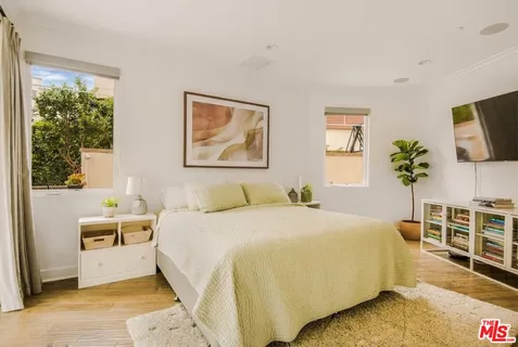 a bedroom with a bed and a flat screen tv