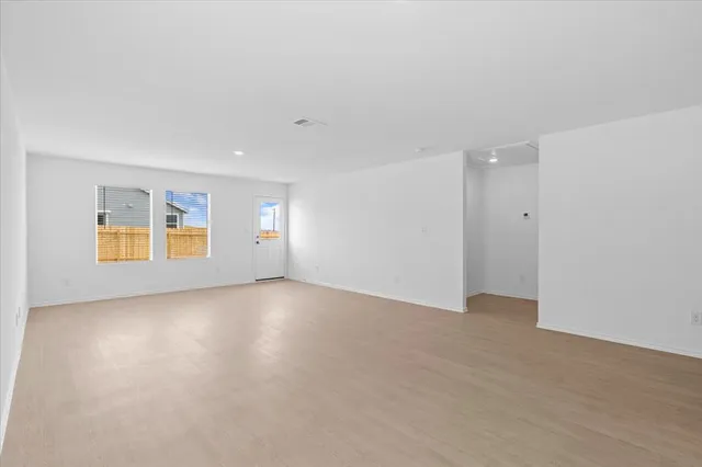 an empty room with entrance and windows