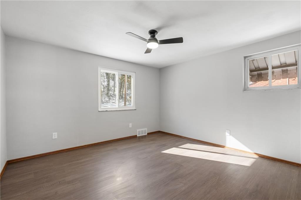 678 Colonial Manor Road Irwin, PA 15642 - Photo 12 of 30 an empty room with wooden floor ceiling fan and windows