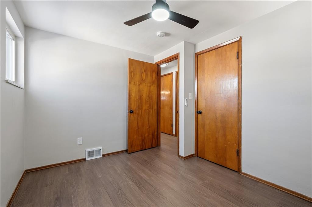 678 Colonial Manor Road Irwin, PA 15642 - Photo 13 of 30 an empty room with wooden floor and a ceiling fan