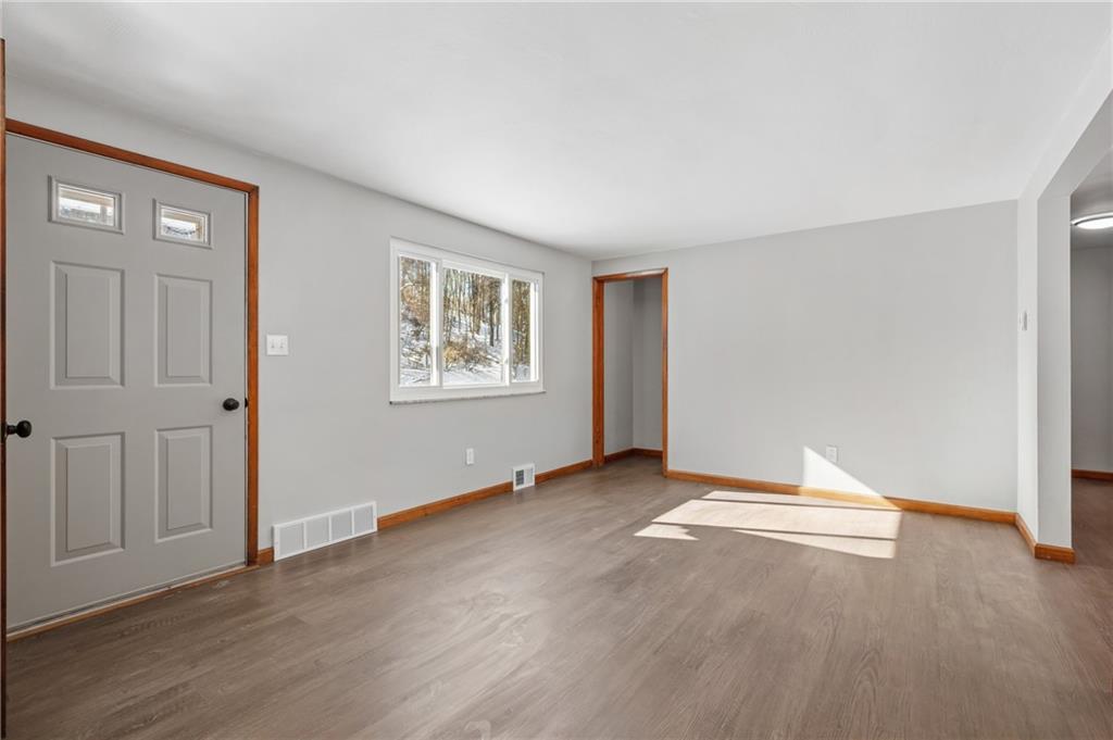 678 Colonial Manor Road Irwin, PA 15642 - Photo 3 of 30 an empty room with wooden floor and windows