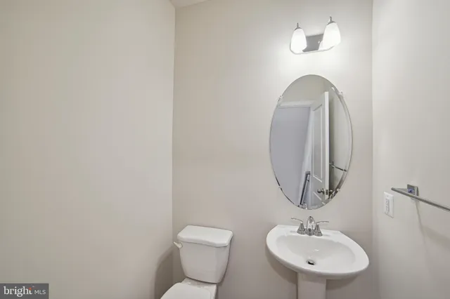 a bathroom with a toilet a sink and mirror