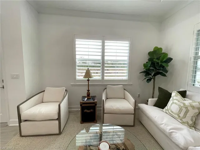 a bedroom with a bed a mirror and a flat tv screen on a dresser