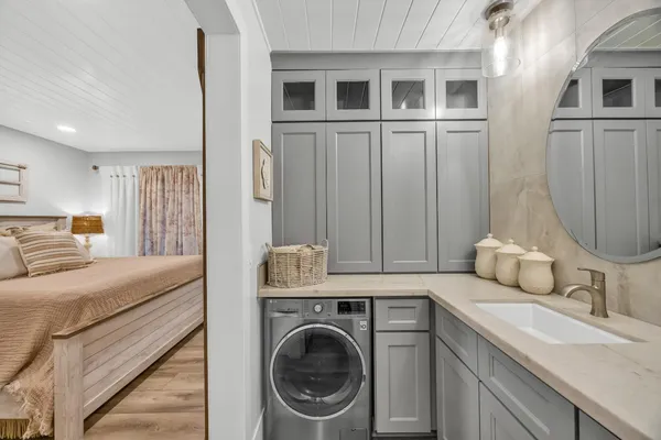a en suite bathroom with a sink a washer and dryer