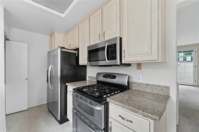 a kitchen with stainless steel appliances granite countertop a stove microwave and refrigerator