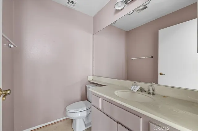 a bathroom with a granite countertop toilet and a sink