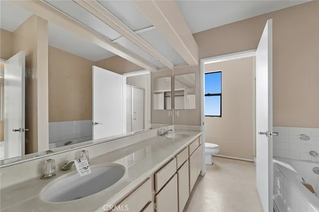 a bathroom with a granite countertop sink mirror and a bathtub