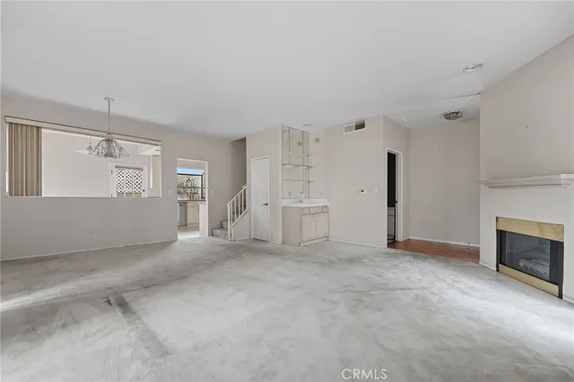 an empty room with fireplace and windows