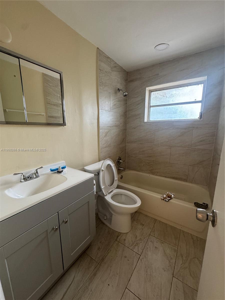 5700 Northwest 15th Street, Unit 2 Lauderhill, FL 33313 - Photo 7 of 7 a bathroom with a toilet a sink a mirror and vanity