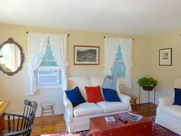 a living room with furniture a wooden floor and a large window