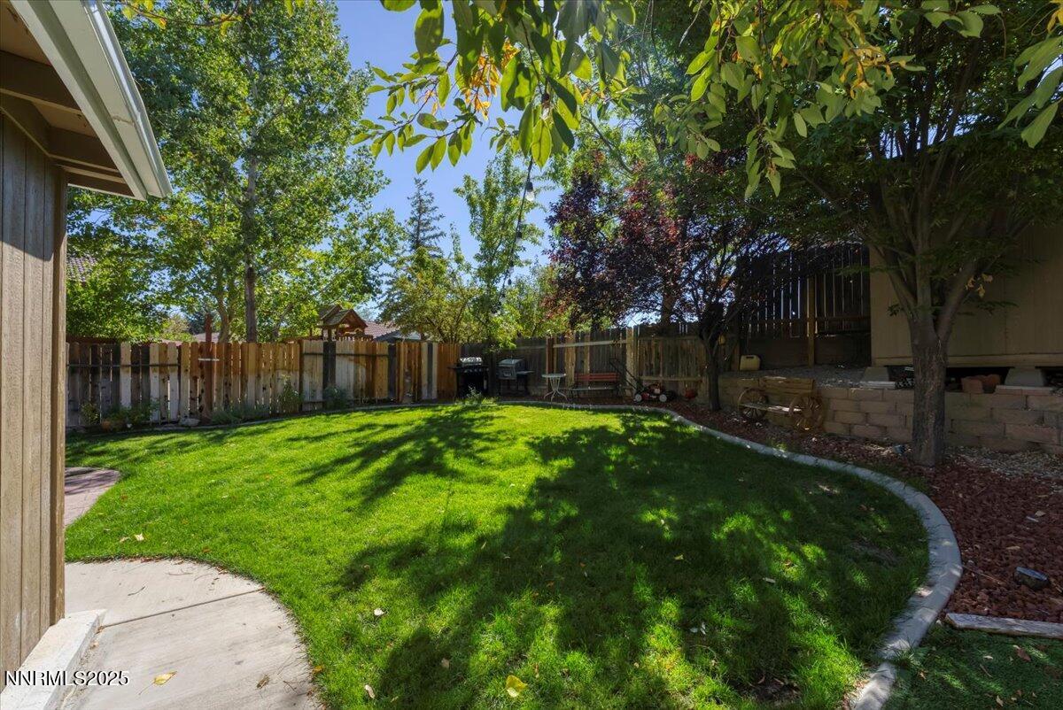 7194 Indigo Court Reno, NV 89506 - Photo 28 of 33 a view of a backyard with wooden fence and large trees
