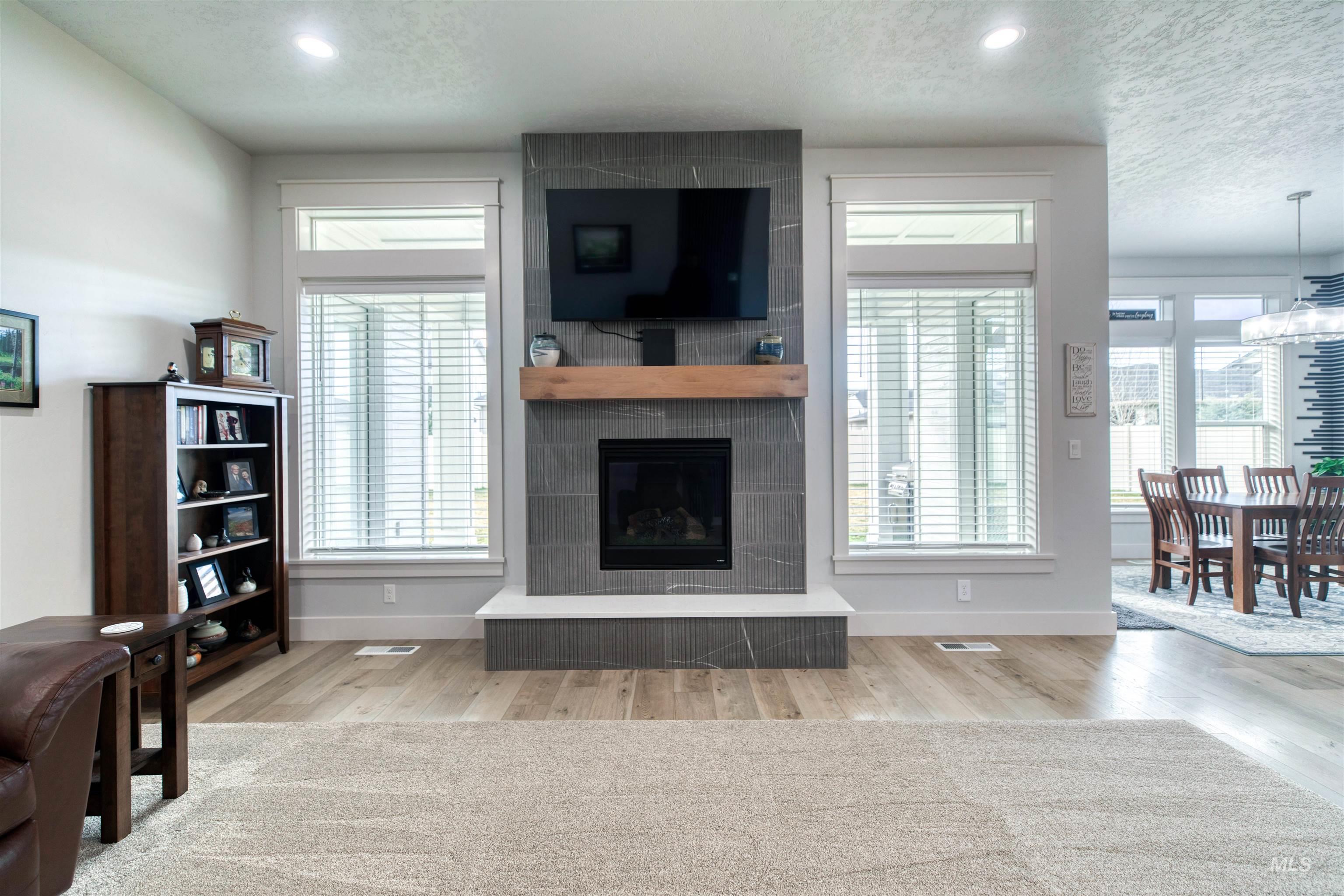 795 East Rio Chico Drive Kuna, ID 83634 - Photo 13 of 34 Living area with a textured ceiling, a tiled fireplace, light wood-style flooring, and recessed lighting