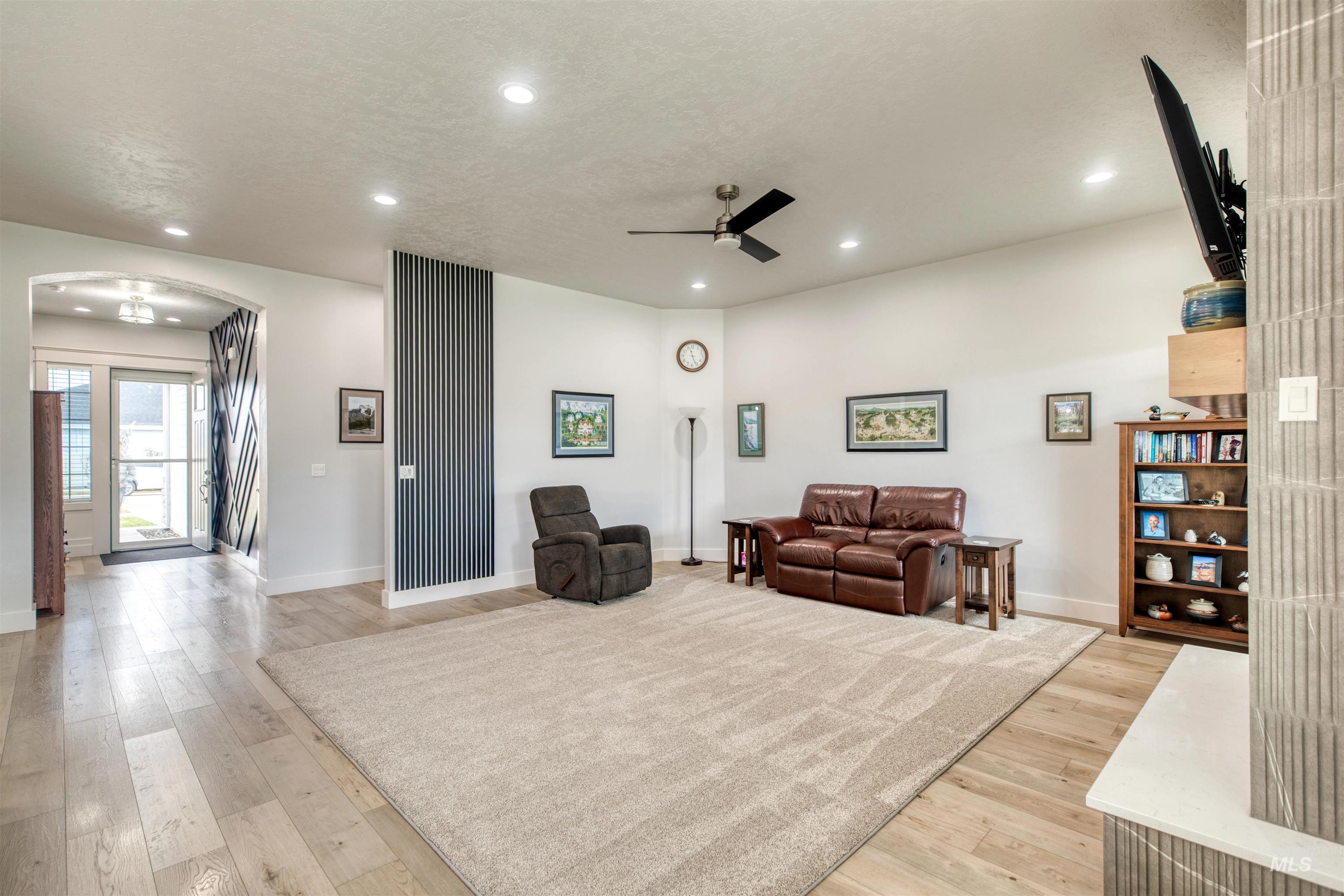 795 East Rio Chico Drive Kuna, ID 83634 - Photo 14 of 34 Living room featuring arched walkways, light wood-style flooring, recessed lighting, and a ceiling fan