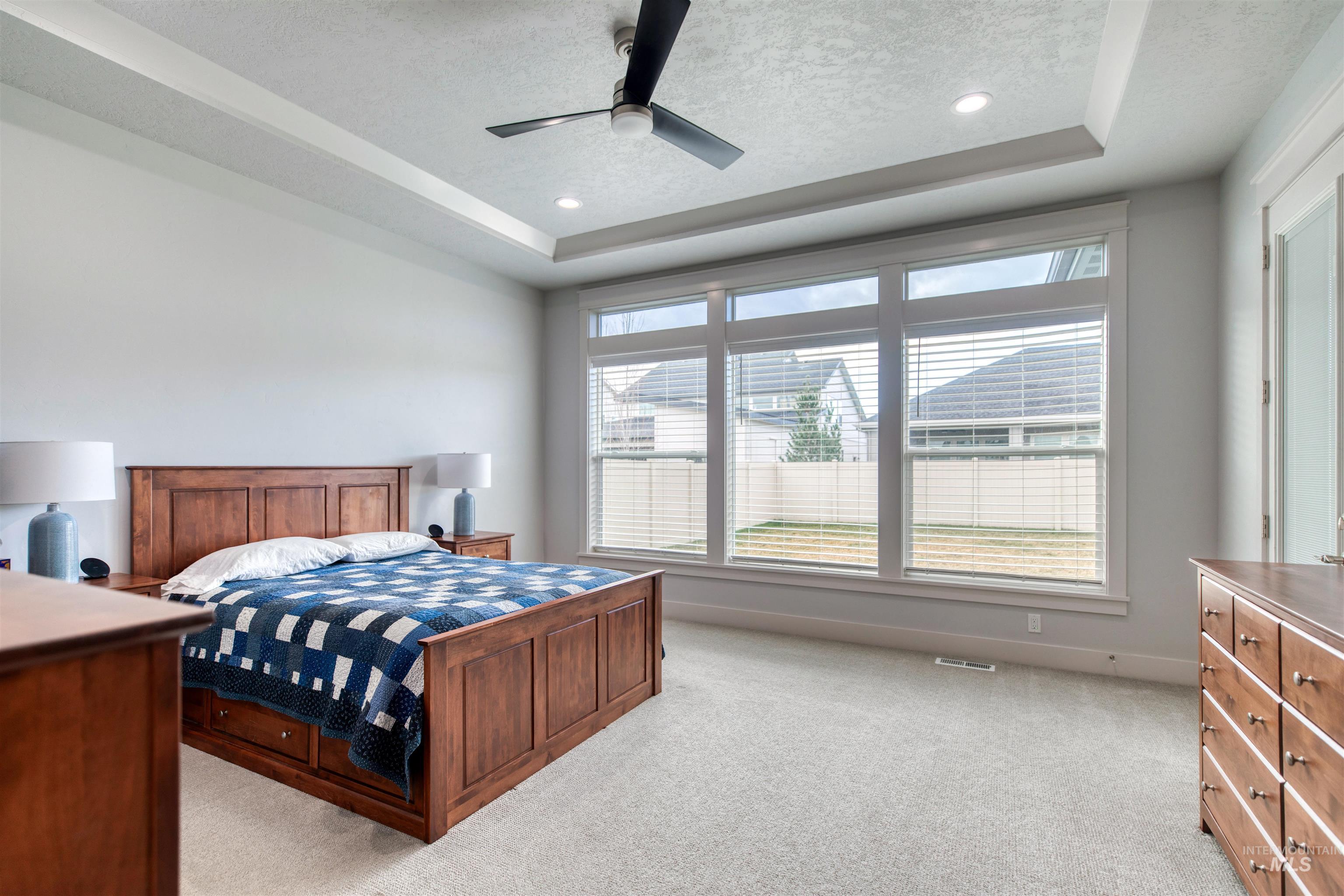 795 East Rio Chico Drive Kuna, ID 83634 - Photo 16 of 34 Bedroom featuring a textured ceiling, light carpet, a raised ceiling, ceiling fan, and recessed lighting