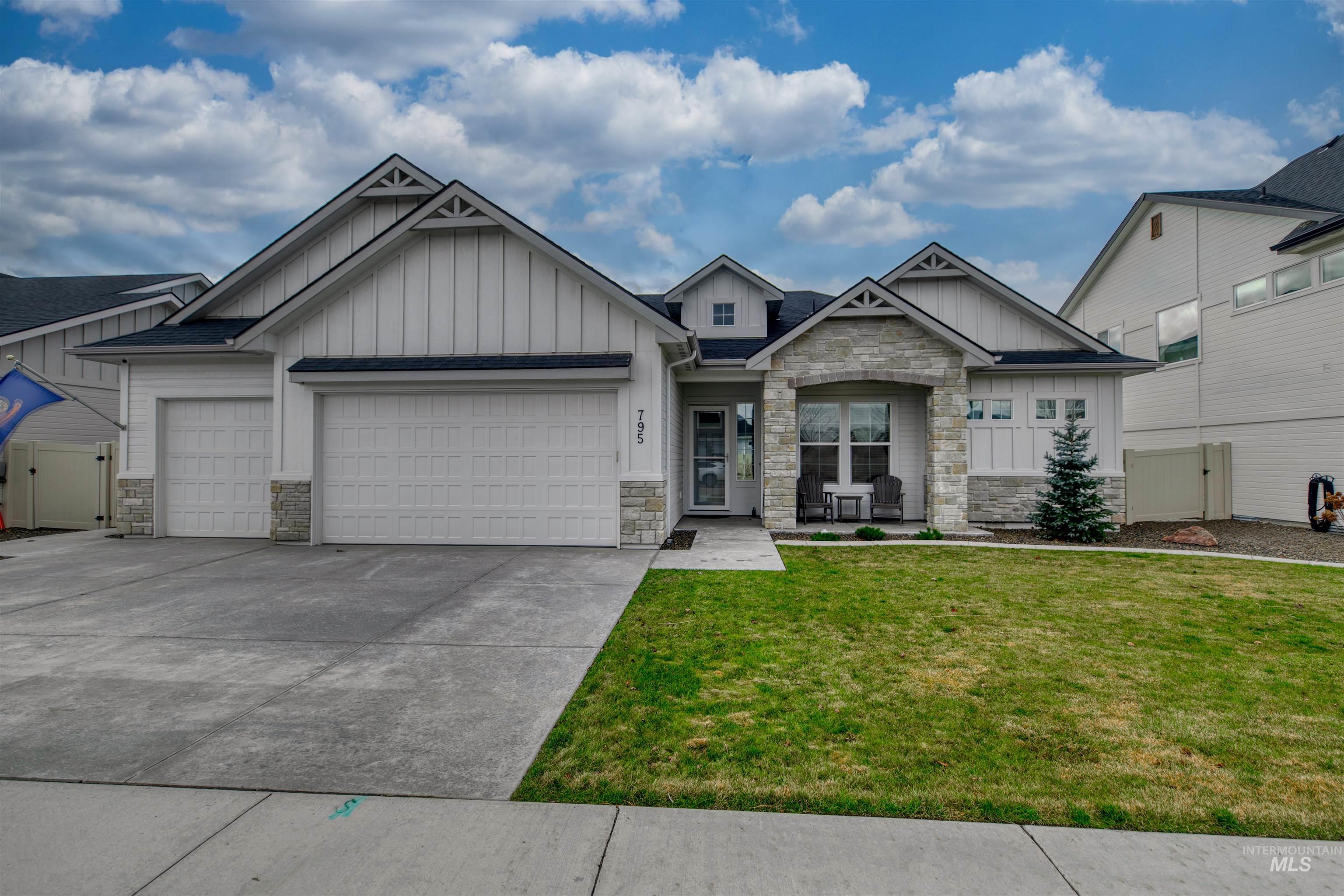 795 East Rio Chico Drive Kuna, ID 83634 - Photo 2 of 34 Craftsman-style home featuring board and batten siding, stone siding, an attached garage, and concrete driveway