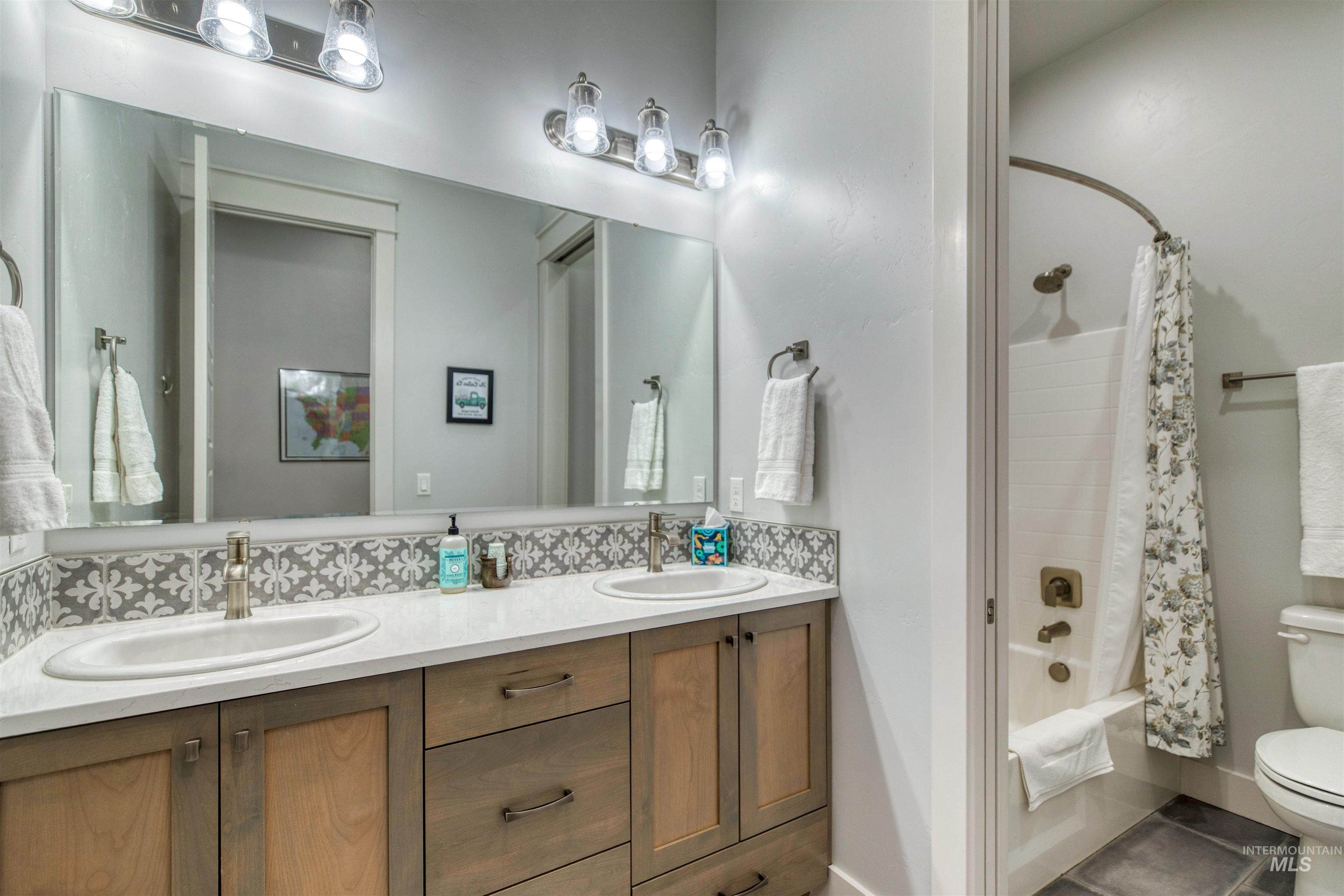 795 East Rio Chico Drive Kuna, ID 83634 - Photo 24 of 34 Full bath with shower / tub combo with curtain, double vanity, tile patterned floors, and backsplash