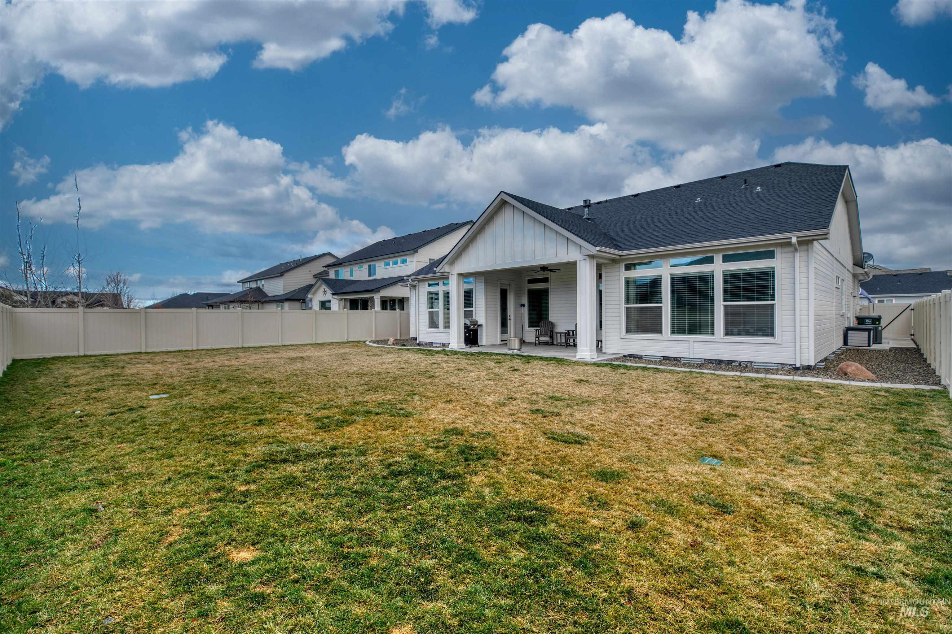 795 East Rio Chico Drive Kuna, ID 83634 - Photo 31 of 34 Back of property featuring a patio, a fenced backyard, ceiling fan, board and batten siding, and roof with shingles